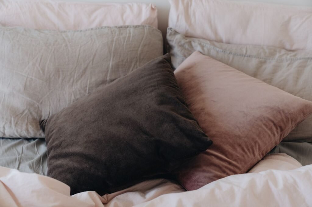 A close-up of comfortable velvet pillows on a neatly made bed, exuding warmth and comfort.