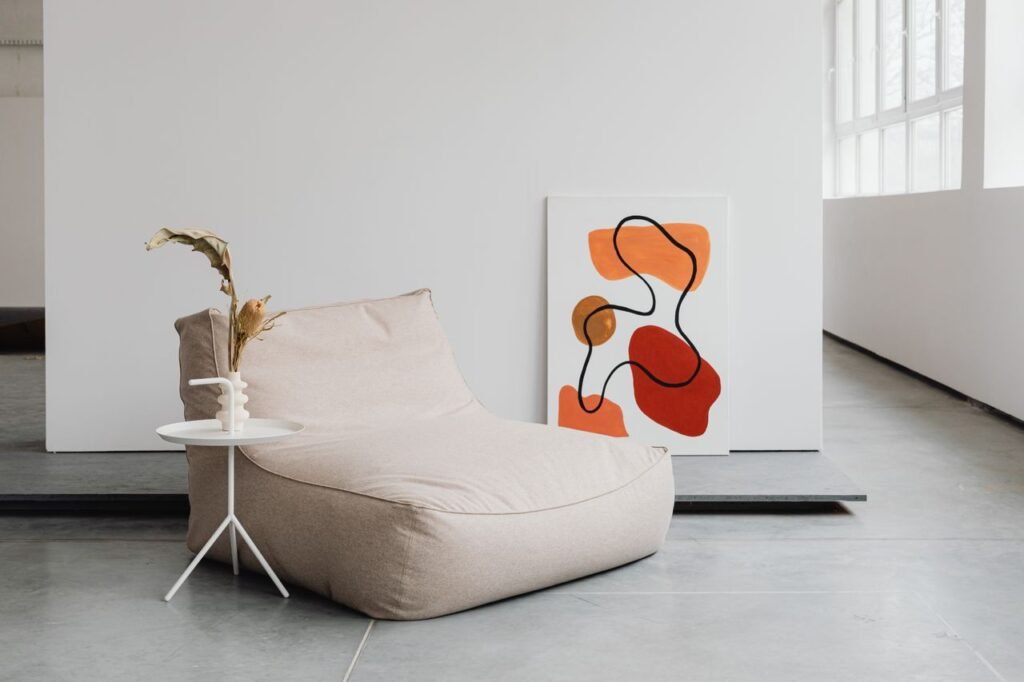 Modern living room with abstract painting and cozy seating in minimalist style.